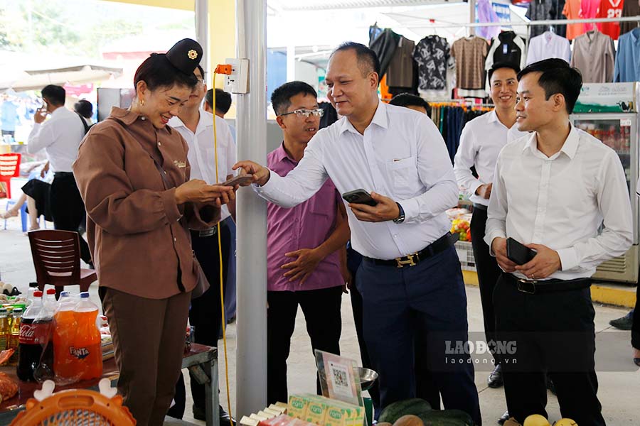 Các đại biểu trải nghiệm thanh toán không dùng tiền mặt tại chợ trung tâm xã Búng Lao.