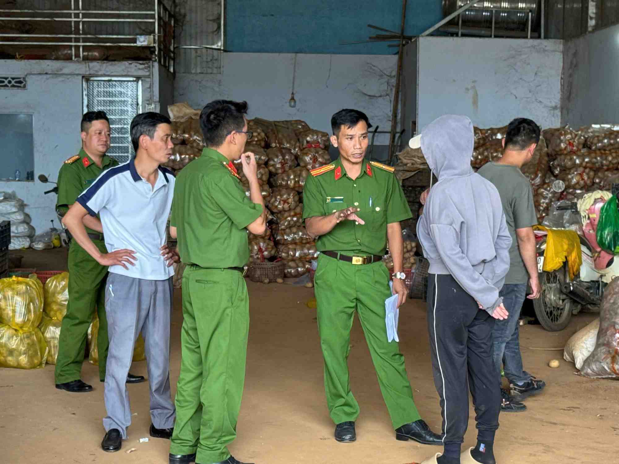 Lực lượng Công an kiểm tra cơ sở kinh doanh trộn đất đỏ vào  khoai tây Trung Quốc để giả mạo khoai tây Đà Lạt. Ảnh: Võ Tùng