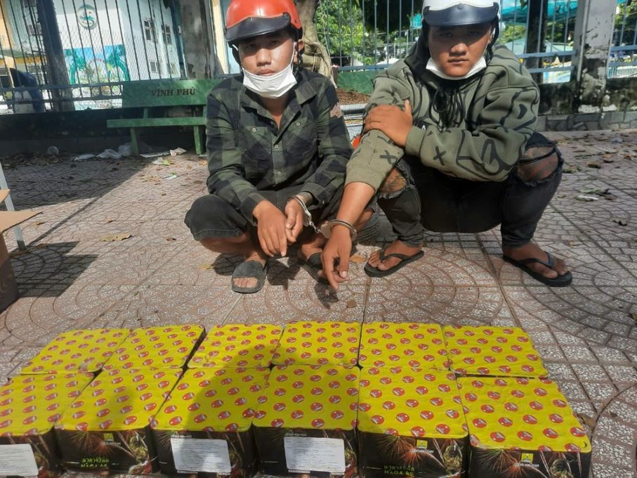 Đối tượng Trần Tấn Đức (bên trái) và Nguyễn Anh Hoàng cùng tang vật pháo nổ. Ảnh: Nghiêm Túc