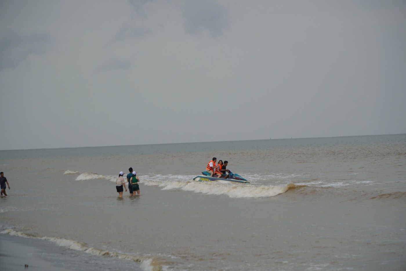 Some tourists take part in the thrilling canoe ride on the sea. Photo: Quach Du