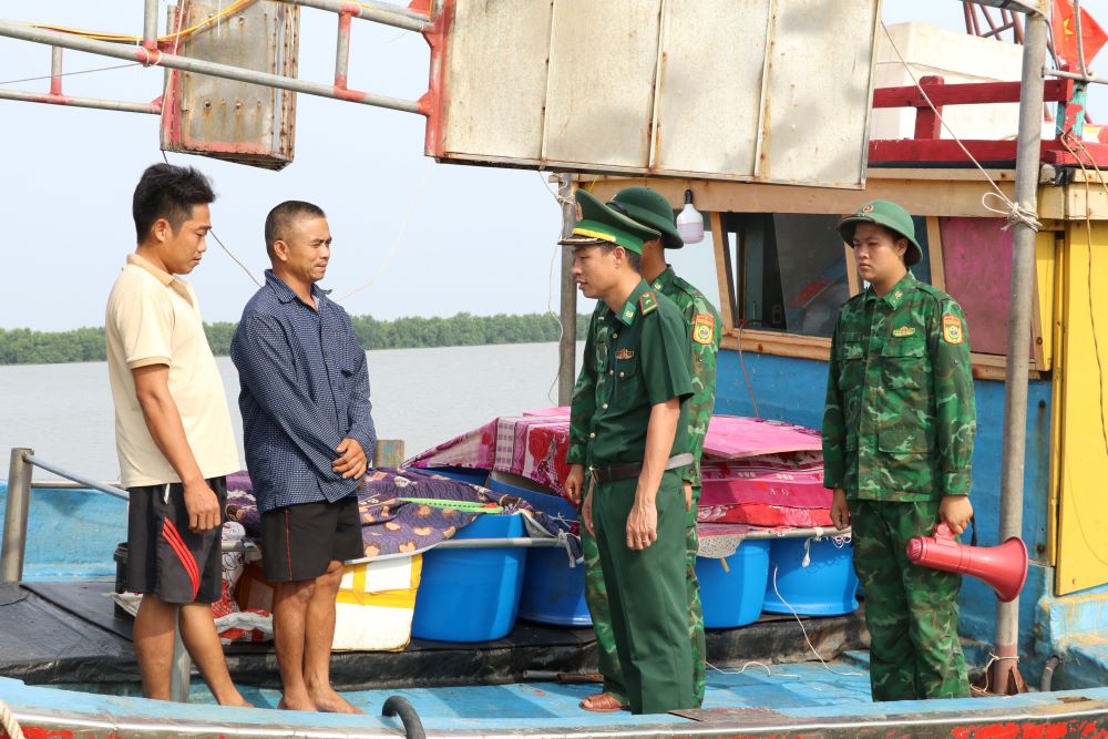 Bộ đội biên phòng Ninh Bình tuyên truyền, hướng dẫn ngư dân neo đậu tàu thuyền. Ảnh: Trần Lâm