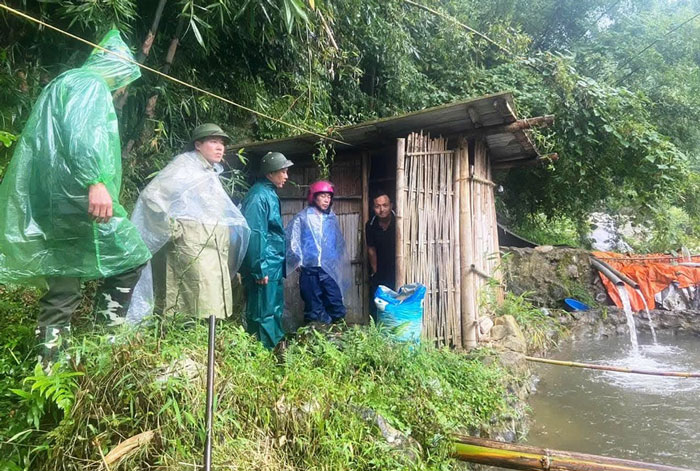 Lực lượng chức năng vận động người dân sinh sống ven suối di chuyển đến nơi an toàn để tránh bão. Ảnh: Hà Thuận