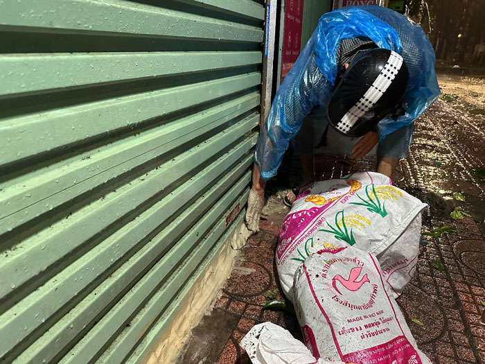 Mr. Duc - Security guard of group 10, Thanh Cong Ward said: "This street section is often flooded, I have to use many bags of soil and put a layer of soil at the base of the rolling door to prevent water from flooding into people's houses." Photo: Viet Anh