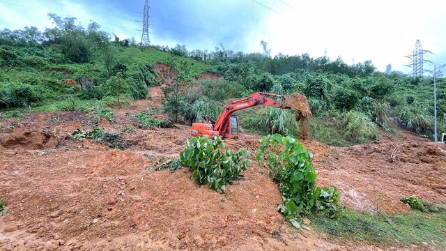 Machinery and vehicles are urgently handling mud to clear the road. Photo: Dang Tinh