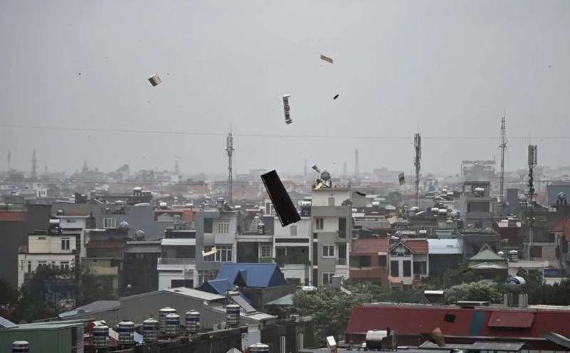 Mảnh vỡ bay trong không trung khi bão số 3 đổ bộ Hải Phòng. Ảnh: AFP