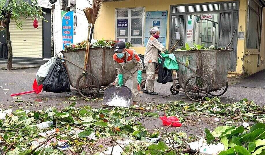 Công nhân môi trường oằn mình dọn rác thải sau bão số 3