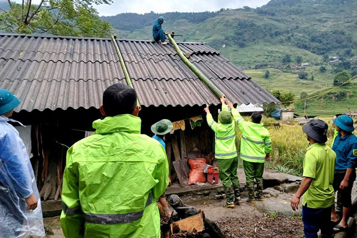 Lực lượng chức năng chằng chống nhà giúp người dân mùa mưa bão. Ảnh: Đơn vị cung cấp