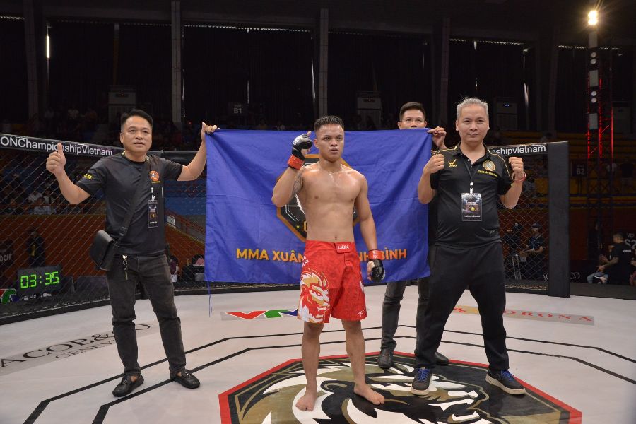 Ở hạng 56kg nam, Bùi Đình Khải (đỏ) gặp Đặng Văn Quý của Vietnam Fight Club. Ở hiệp 2, Đình Khải chủ động với loạt đòn ở tư thế đánh đứng khiến Văn Quý không thể tiếp tục thi đấu. Trận đấu dừng lại ở thời điểm 1 phút 25 giây sau tình huống võ sĩ ở góc đài đỏ thực hiện trúng đích loạt đòn đấm móc. Chiến thắng knock-out cho Bùi Đình Khải. Ảnh: MMA