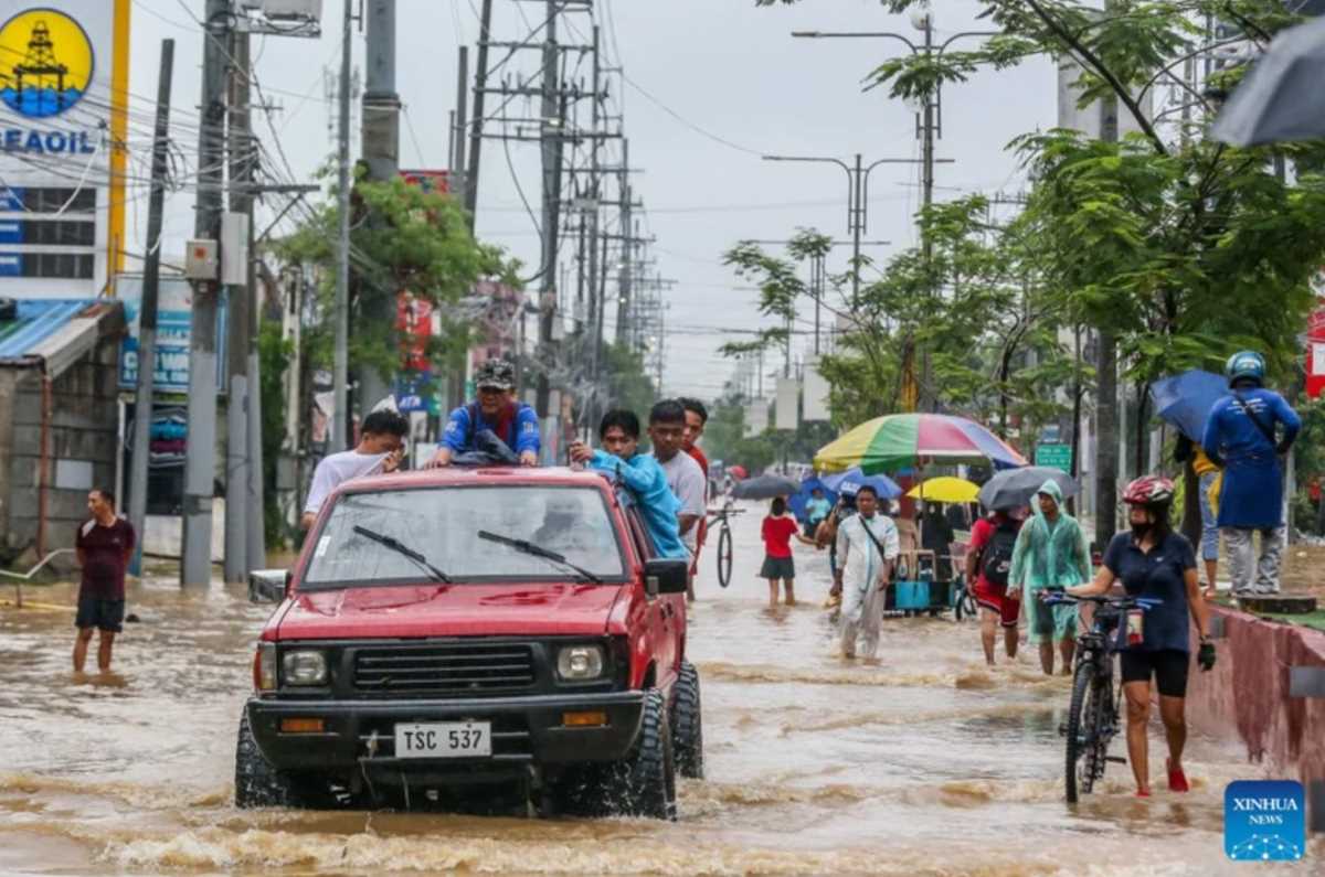 Người dân di chuyển trên tuyến đường bị ngập úng tại tỉnh Rizal, Philippines, ngày 2.9.2024. Ảnh: Xinhua