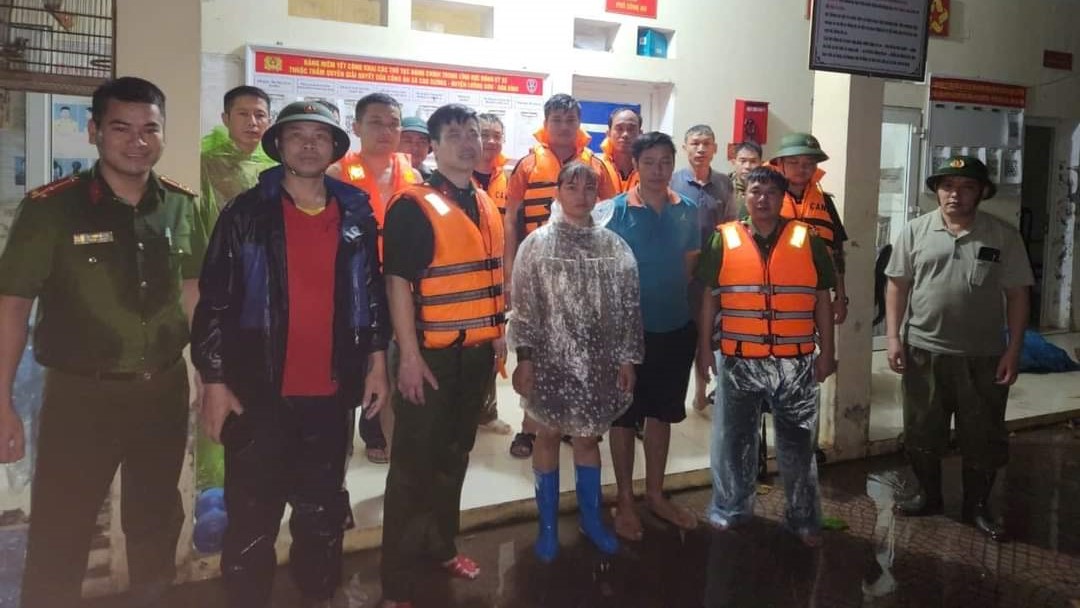 Lực lượng công an giải cứu đôi vợ chồng thoát khỏi dòng nước lũ chảy xiết an toàn. Ảnh: Công an huyện Lương Sơn.

