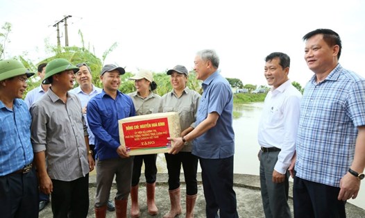 Phó Thủ tướng Thường trực Chính phủ Nguyễn Hòa Bình tặng quà cho cán bộ thủy nông làm nhiệm vụ ứng trực tiêu thoát nước tại trạm bơm An Quốc (xã Quốc Tuấn, huyện Kiến Xương). Ảnh: Nam Hồng