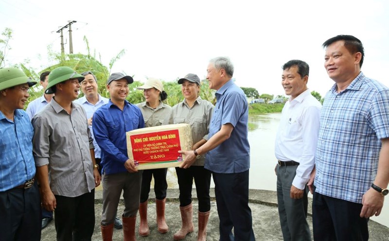 Phó Thủ tướng Thường trực Chính phủ Nguyễn Hòa Bình tặng quà cho cán bộ thủy nông làm nhiệm vụ ứng trực tiêu thoát nước tại trạm bơm An Quốc (xã Quốc Tuấn, huyện Kiến Xương). Ảnh: Nam Hồng