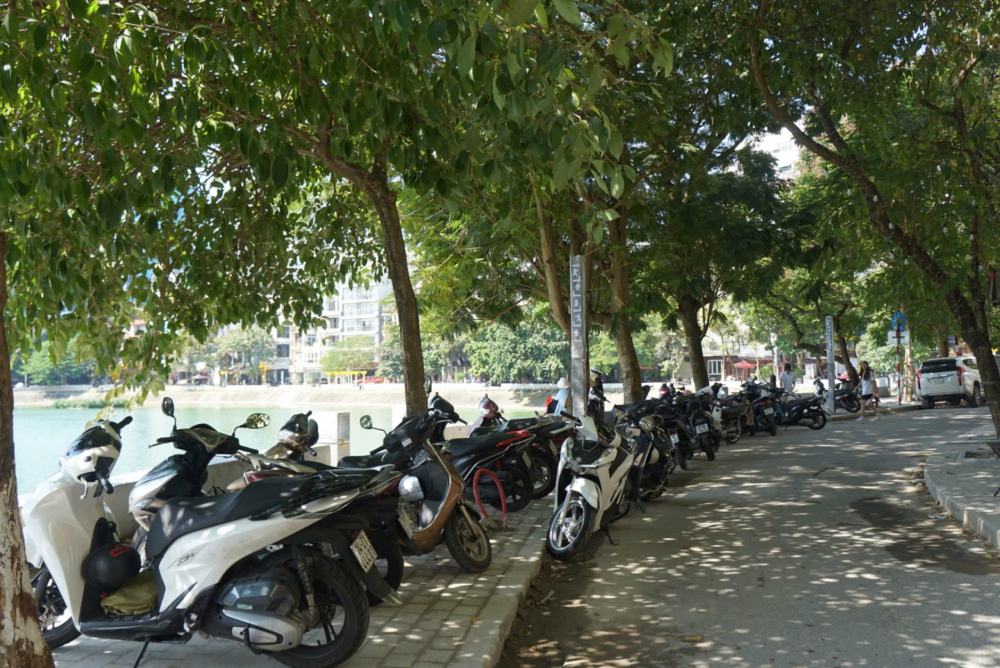 Shops occupy the sidewalks along the lake as parking spaces. Photo: Cong Hoa