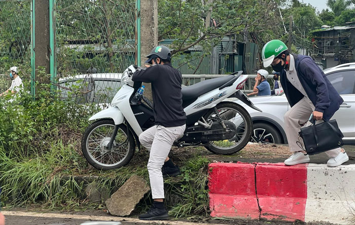 Nhiều phương tiện phải bê xe qua dải phân cách để sang làn đường khác. Ảnh: Văn Thắng