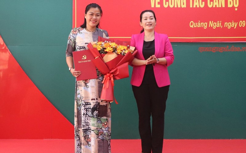 Ms. Dinh Thi Hong Minh - Deputy Secretary of Quang Ngai Provincial Party Committee presented the decision and flowers to congratulate Ms. Dinh Thi Bac. Photo: Vien Nguyen