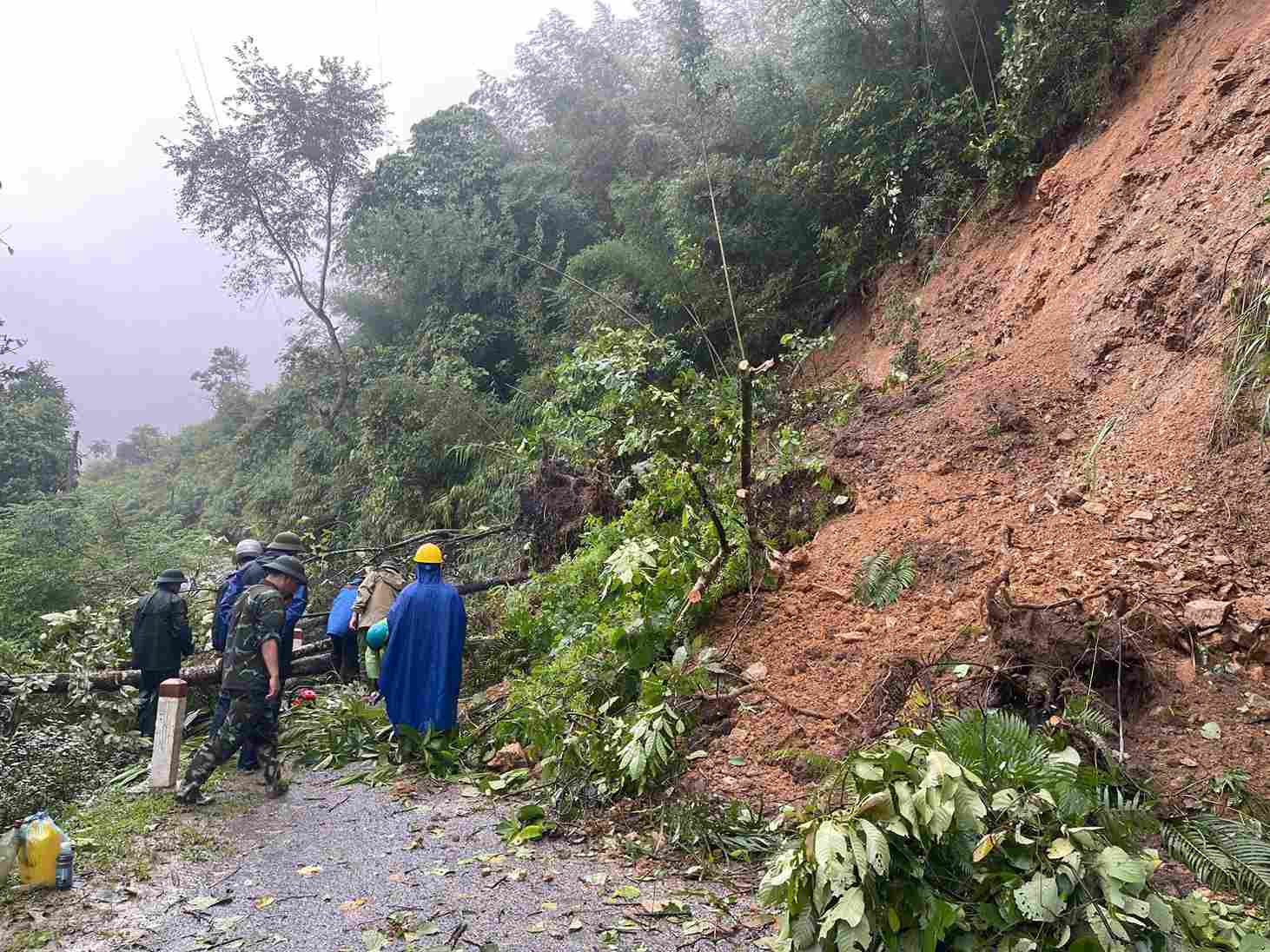 Lực lượng chức năng đang trên đường tiếp cận chiếc xe khách mắc kẹt trong sạt lở. Ảnh: Kim Dung.