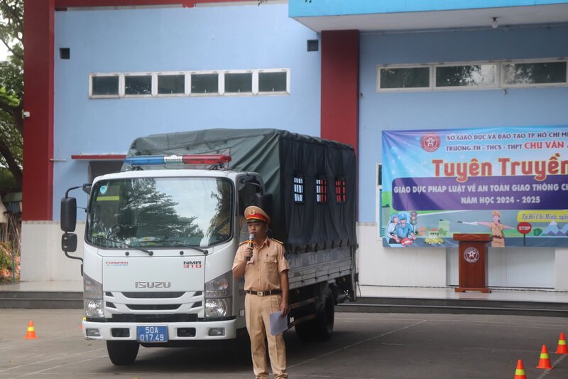 CSGT TPHCM tuyên truyền về điểm mù của xe tải trọng lớn để học sinh biết đề phòng tai nạn. Ảnh: Ngọc Duy