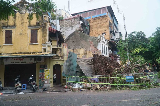 Corner of old house collapsed with tree in storm. Photo: Phi Hung