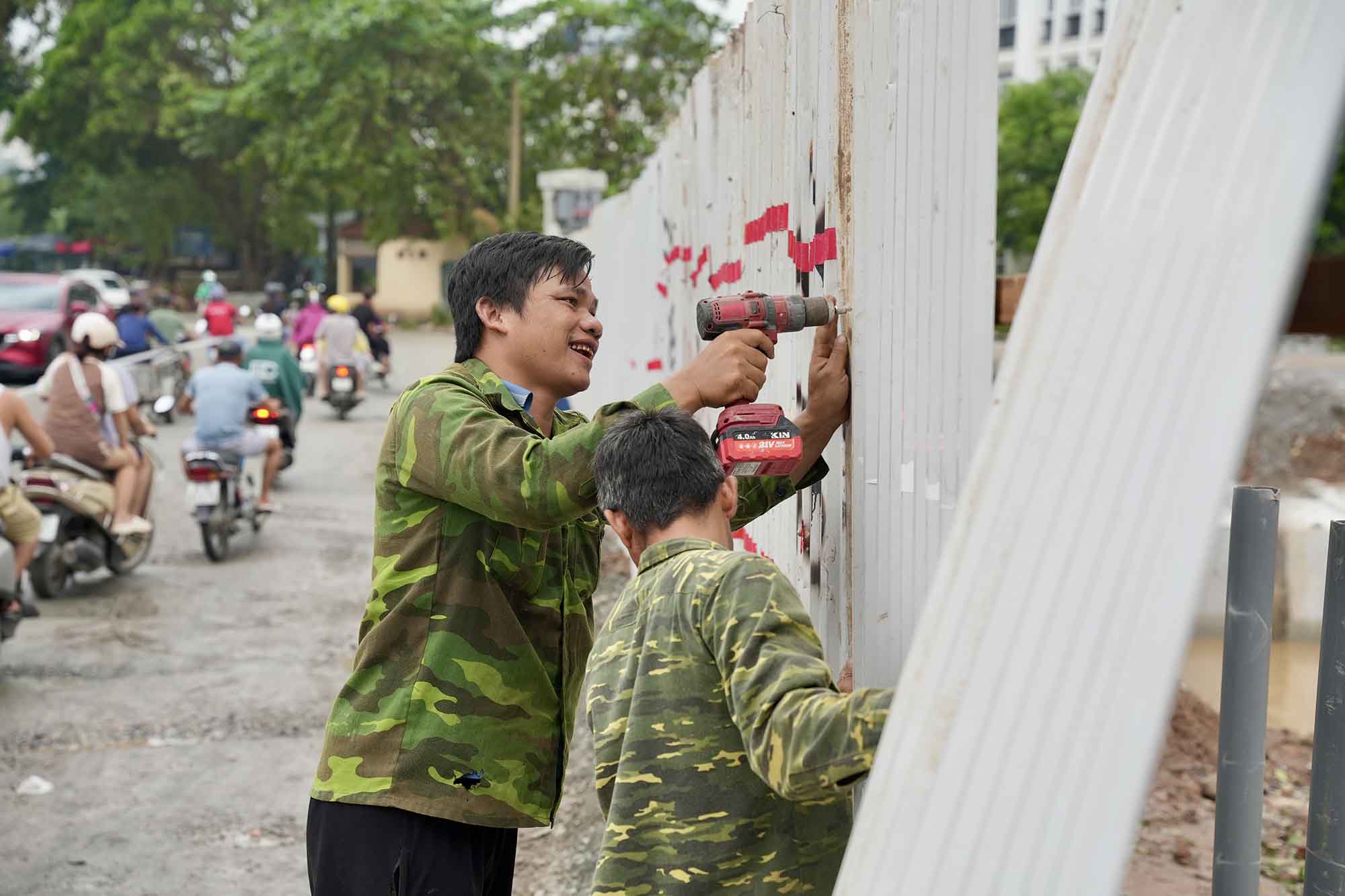 Công nhân lắp đặt rào chắn đoạn nút giao đường 70 để phục vụ thi công dự án. Ảnh: Hữu Chánh