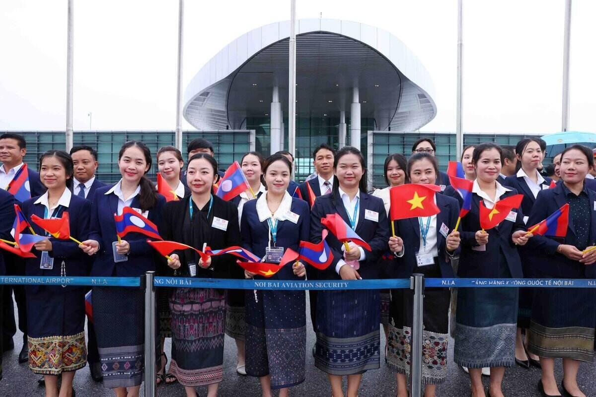 Embassy staff and a large number of Lao students went to Noi Bai International Airport to welcome Lao General Secretary and President Thongloun Sisoulith, his wife and the high-ranking delegation of the Lao Party and State on a State visit to Vietnam. Photo: VNA