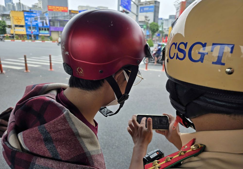 CSGT cho nguoi vi pham xem lai hinh anh vi pham. Anh: Minh Vuong