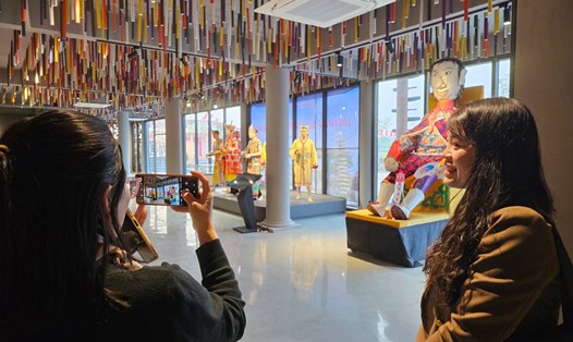 Du khách tham quan, chụp ảnh tại Nhà Văn hóa dân tộc Sán Dìu, huyện Vân Đồn, tỉnh Quảng Ninh. Ảnh: Đoàn Hưng