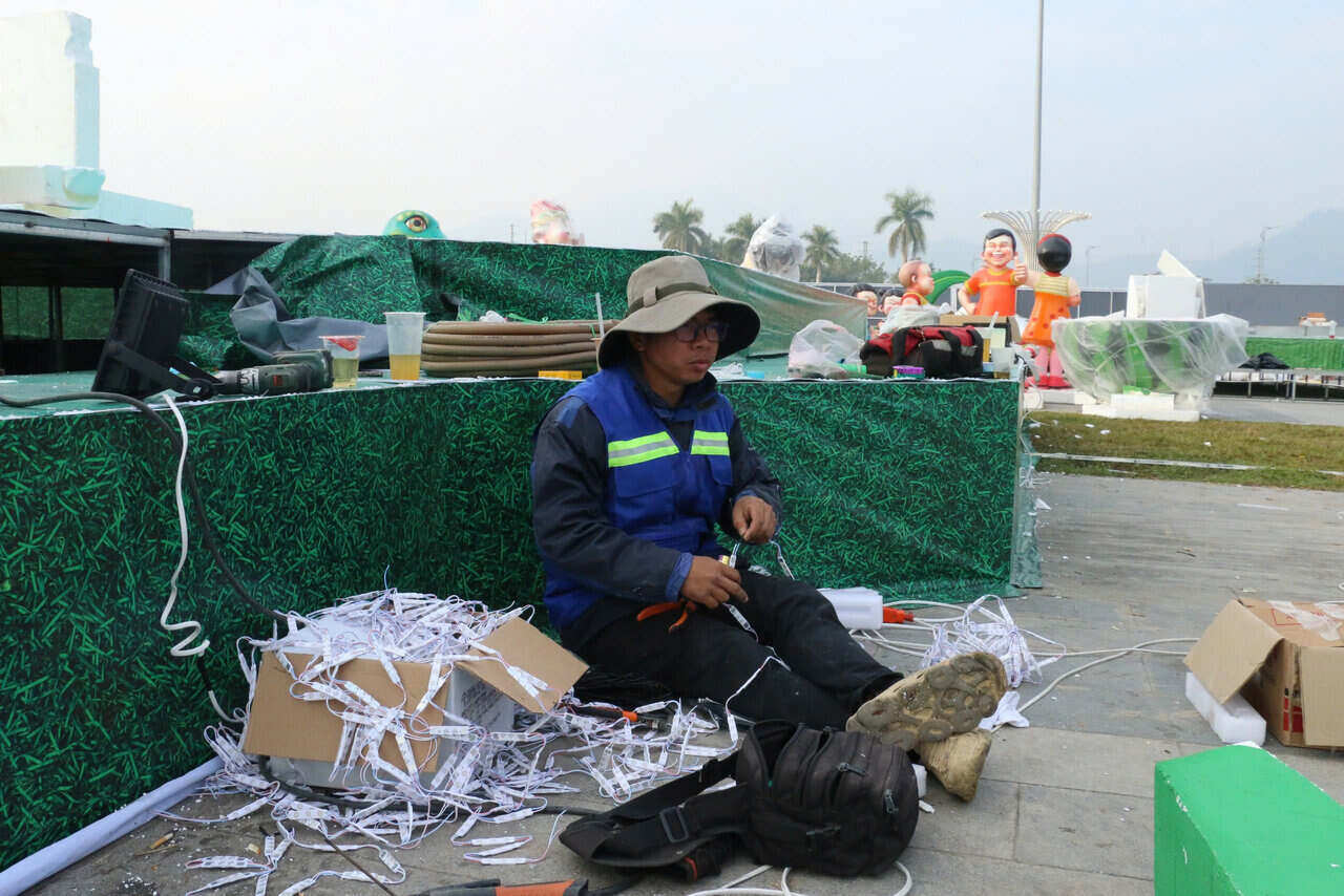 Anh Nguyễn Thành Nhân tất bật lắp đèn trang trí linh vật. Ảnh: Yên San