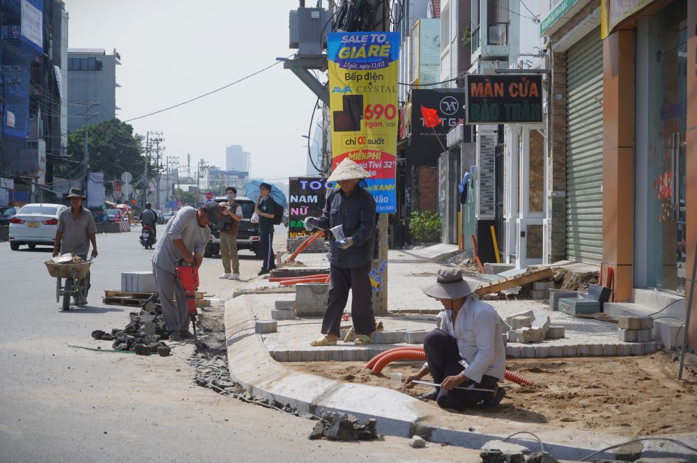 Cong nhan dang thuc hien viec bo via he va thi cong lat nen via he. Ảnh: Anh Tu   