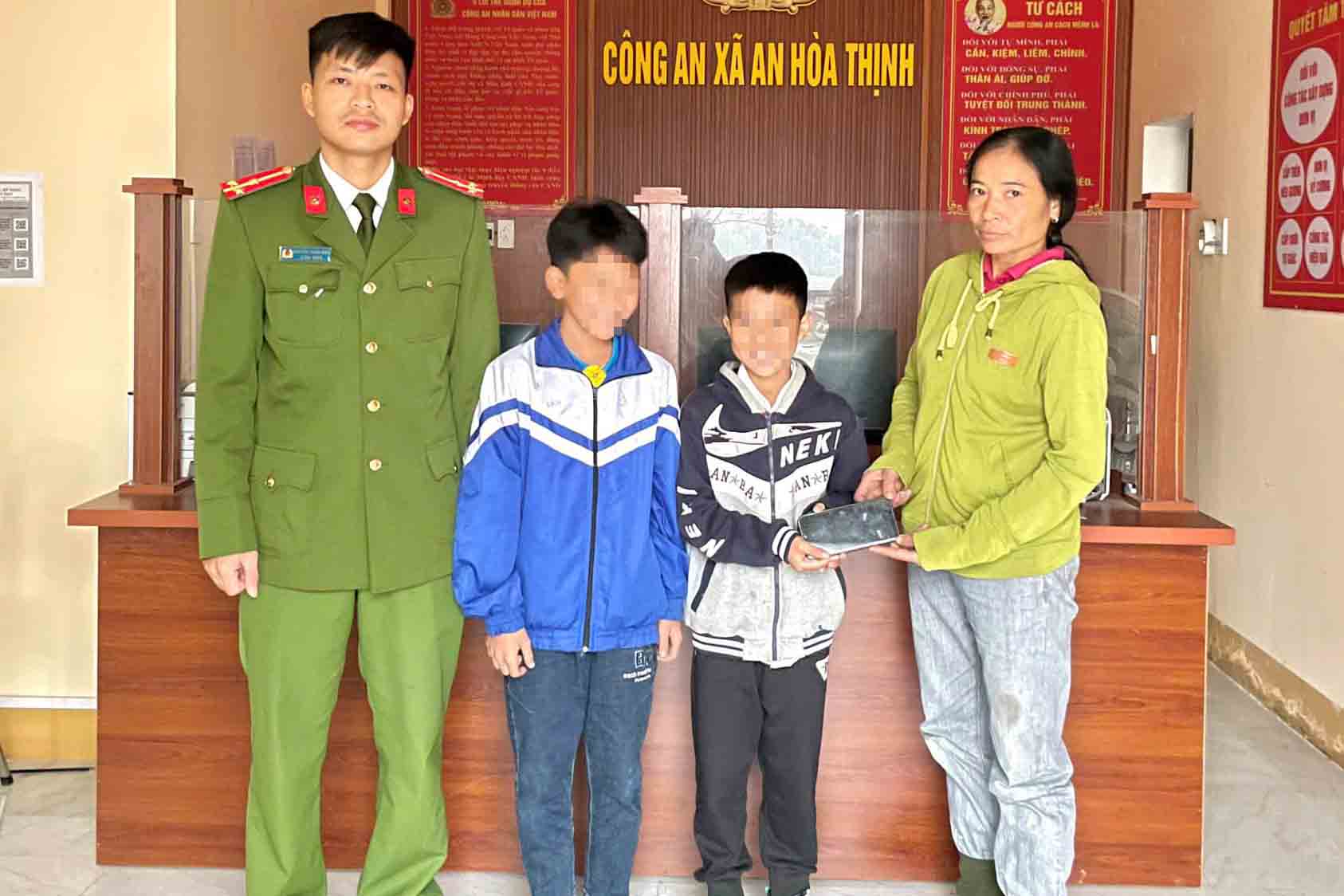 Two students from An Hoa Thinh Primary School returned the phone they found to Ms. Hong. Photo: Ha Tinh Police