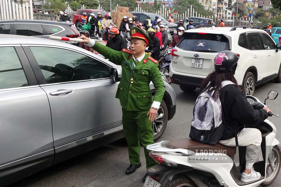 Authorities in Hanoi work through lunch to regulate and direct traffic. Photo: Reporter Group