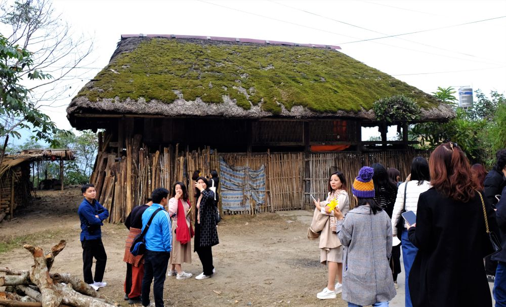 Tourists visit the moss-roofed house in Khuoi My.
