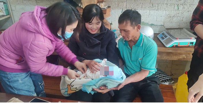 People take the abandoned newborn baby boy to a medical facility for a health check. Photo: Bao Trung