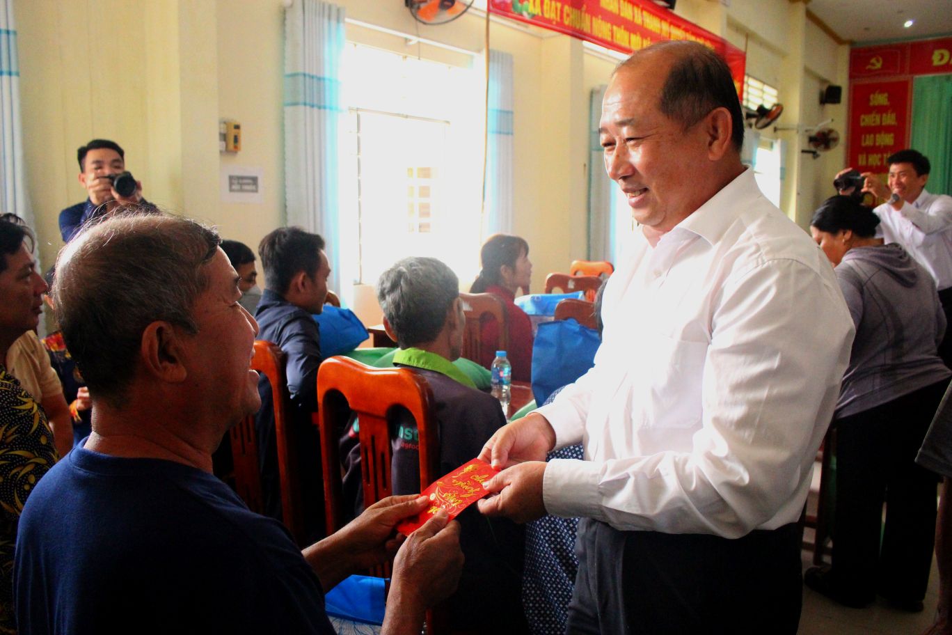 Bac si Doan Tan Buu - Giam doc So Y te tinh Dong Thap- an can trao tan tay dai dien cac gia dinh co nhieu cong lao cuu mang nganh y te Kien Phong trong khang chien. 