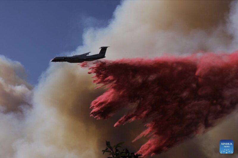 US aircraft spray fire retardant from above. Photo: Xinhua
