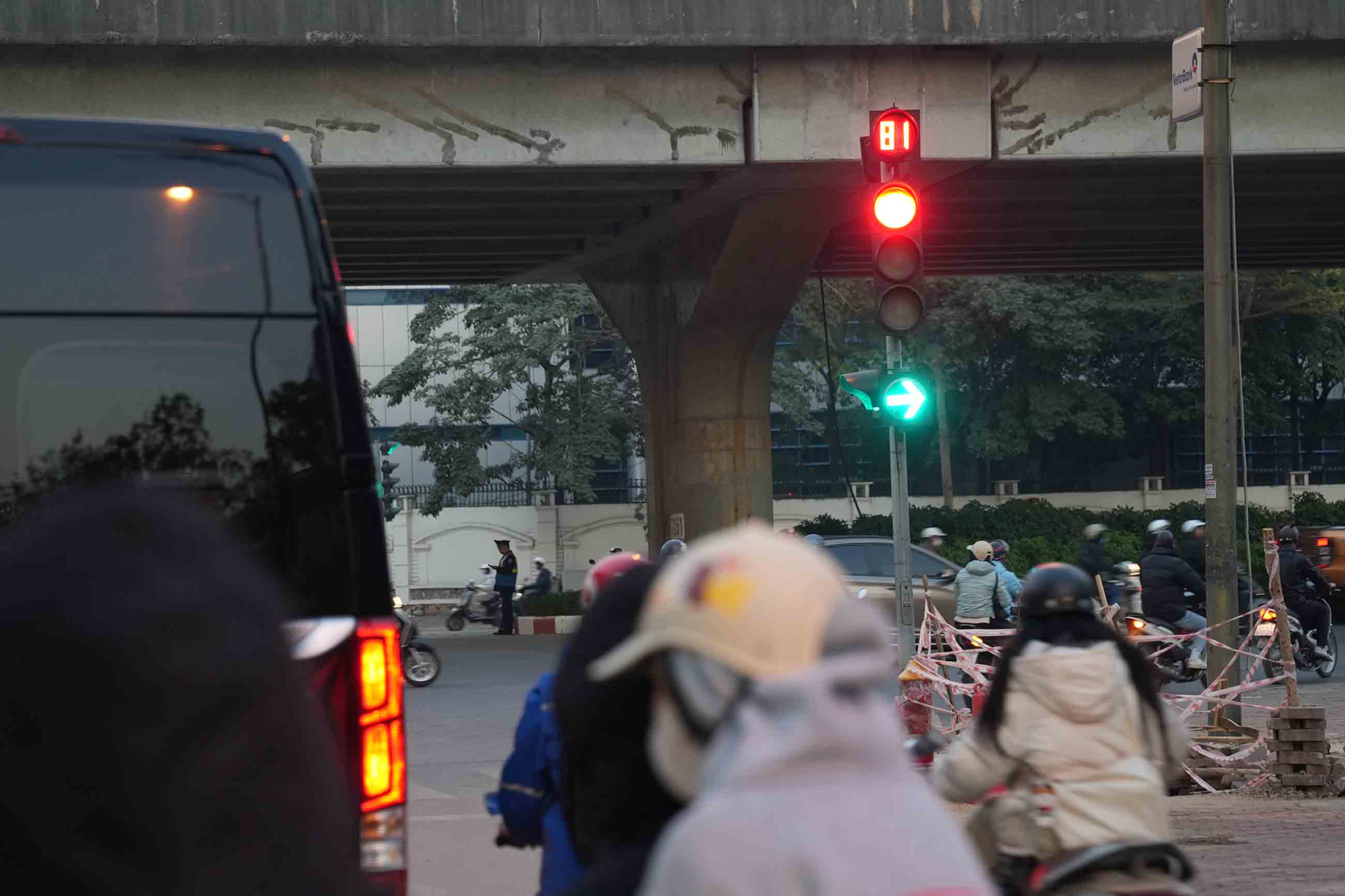 Người dân chờ đèn đỏ tại nút giao Đỗ Đức Dục - Phạm Hùng, chiều 13.1. Ảnh: Hữu Chánh