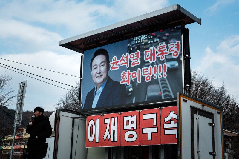 A supporter speaks in front of an image of impeached South Korean President Yoon Suk Yeol. Photo: AFP