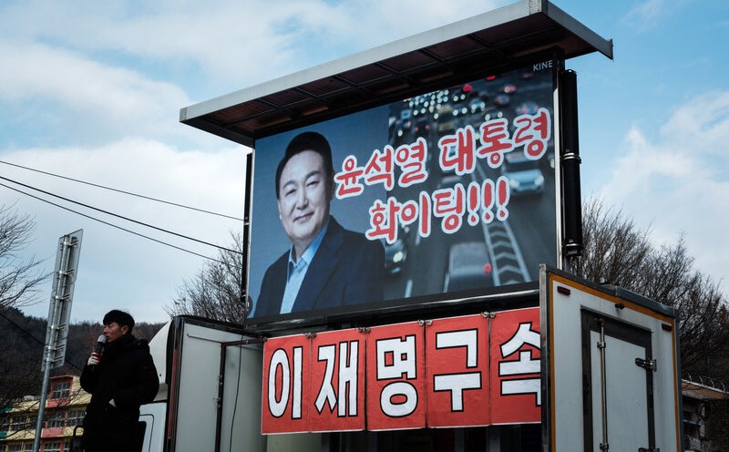 A supporter speaks in front of an image of impeached South Korean President Yoon Suk Yeol. Photo: AFP