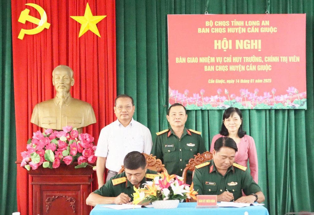 Thu truong Bo Chi huy Quan su tinh va lanh dao huyen Can Giuoc chung kien ky ket ban giao chuc vu Chinh tri vien Ban Chi huy Quan su huyen Can Giuoc. Anh: cangiuoc.longan.gov.vn