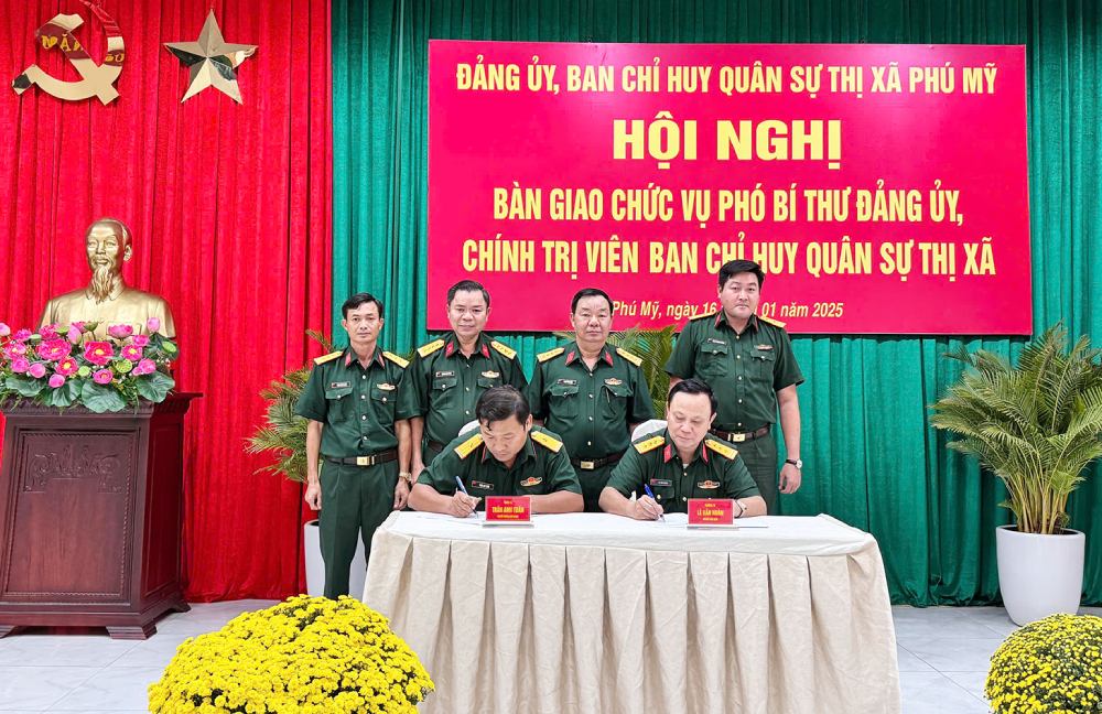 Thuong ta Le Van Hoan va Thieu ta Tran Anh Tuan ky bien ban giao - nhan chuc vu Chinh tri vien Ban Chi huy Quan su thi xa Phu My. Anh: baobariavungtau.com.vn 