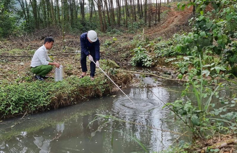 Authorities took water samples from the pig farm discharging waste into the environment for testing. Photo: Duc Tai