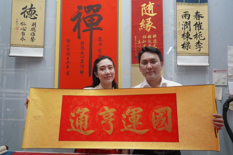 Calligrapher couple Luong Trieu Minh and his wife and the parallel sentence with the four words "National luck is smooth". Photo: HO ANH TU