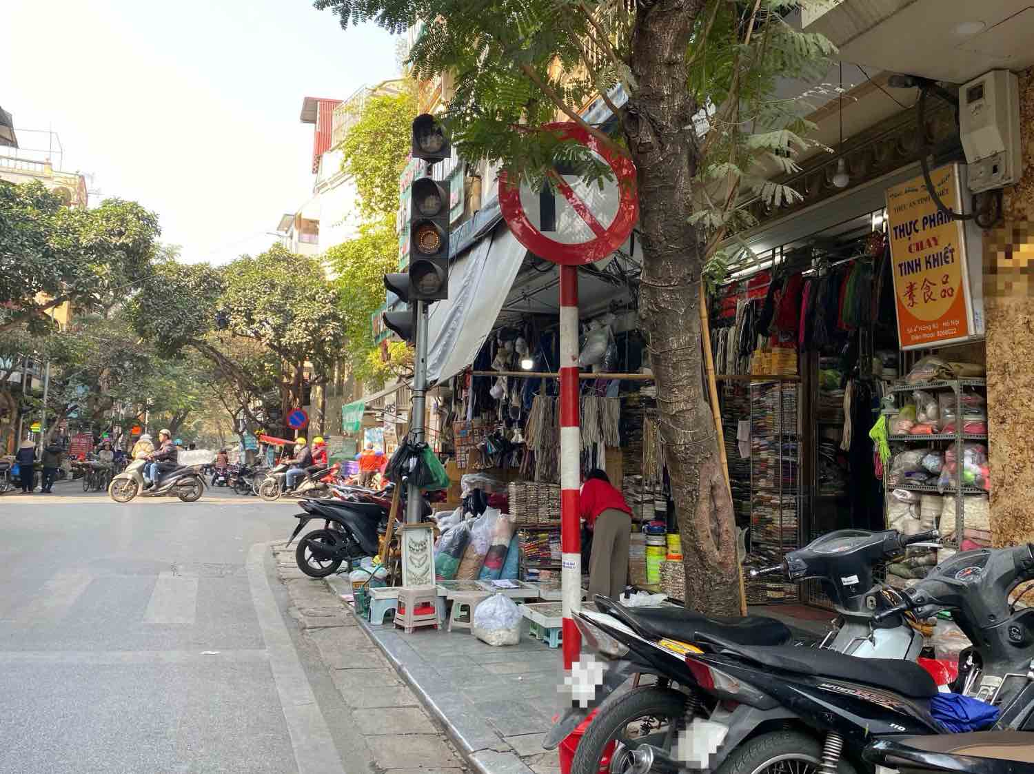 Biển báo cấm rẽ phải trên phố Hàng Bồ (quận Hoàn Kiếm, Hà Nội) bị che khuất một phần, khiến người dân khó nhận biết. Ảnh: Nhật Minh