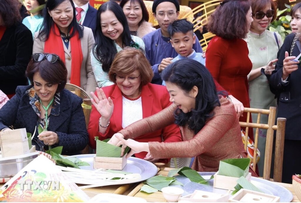 Madam Ngo Phuong Ly and Ambassadors experience wrapping and boiling banh chung. Photo: VNA