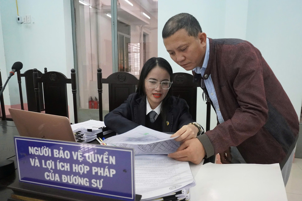 Mr. Le Quang Vinh (Ms. Duong's husband) and his lawyer discuss before the appeal hearing of the civil lawsuit against Sacombank. Photo: Huu Long.