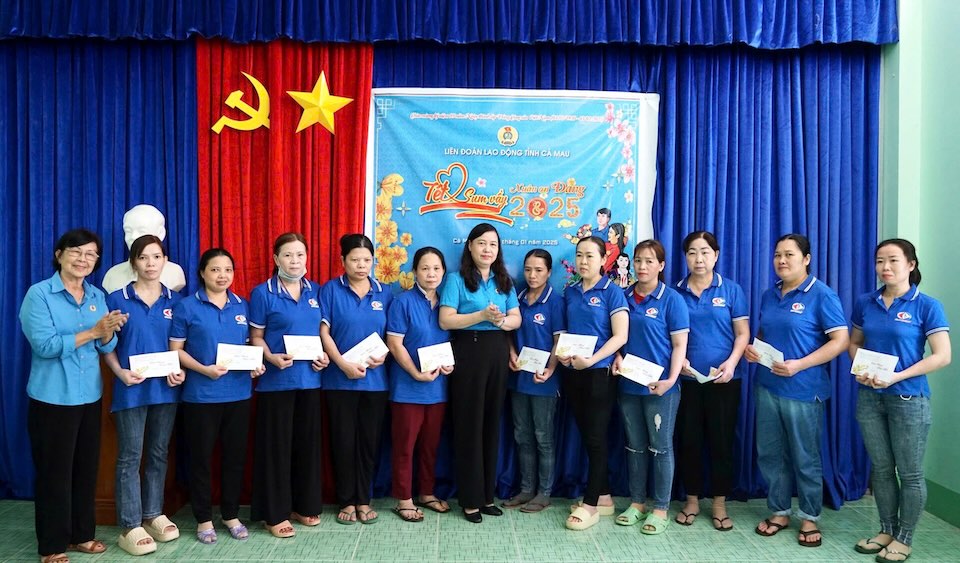 Chairman of Ca Mau Provincial Labor Federation Huynh Ut Muoi (standing in the middle) presents gifts to workers of Ca Mau Seafood Joint Stock Company. Photo: Thieu Vu