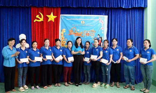 Chủ tịch LĐLĐ tỉnh Cà Mau Huỳnh Út Mười (đứng giữa) tặng quà cho công nhân Công ty Cổ phần Thuỷ sản Cà Mau. Ảnh: Thiệu Vũ