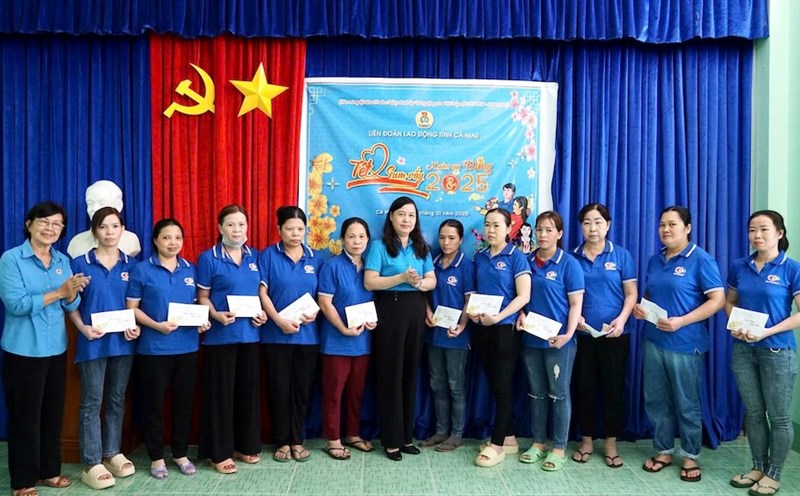 Chairman of Ca Mau Provincial Labor Federation Huynh Ut Muoi (standing in the middle) presents gifts to workers of Ca Mau Seafood Joint Stock Company. Photo: Thieu Vu