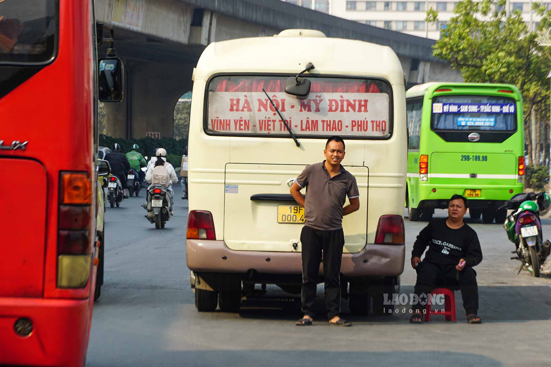 Mot nha xe cho xe khach do giua duong, nhan vien phu xe ke ghe ngoi doi khach.