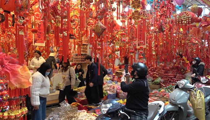 Bustling Tet market, candy and dried food stalls full of people