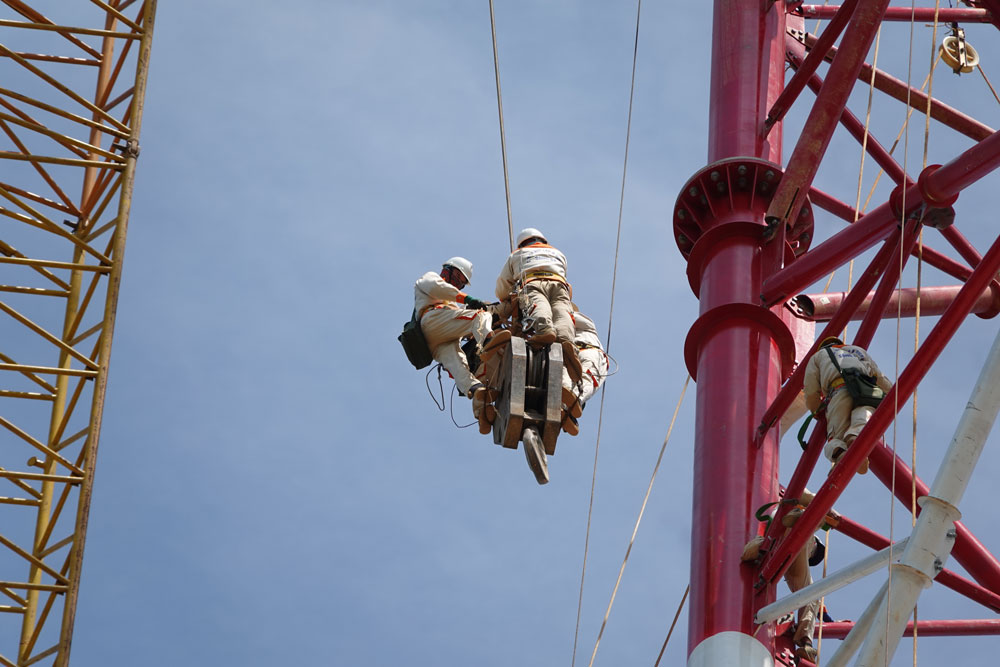 Every day, workers are lifted by crane to construct electric pole No. 175 in Ha Tinh at a very dangerous height. Photo: Tran Tuan